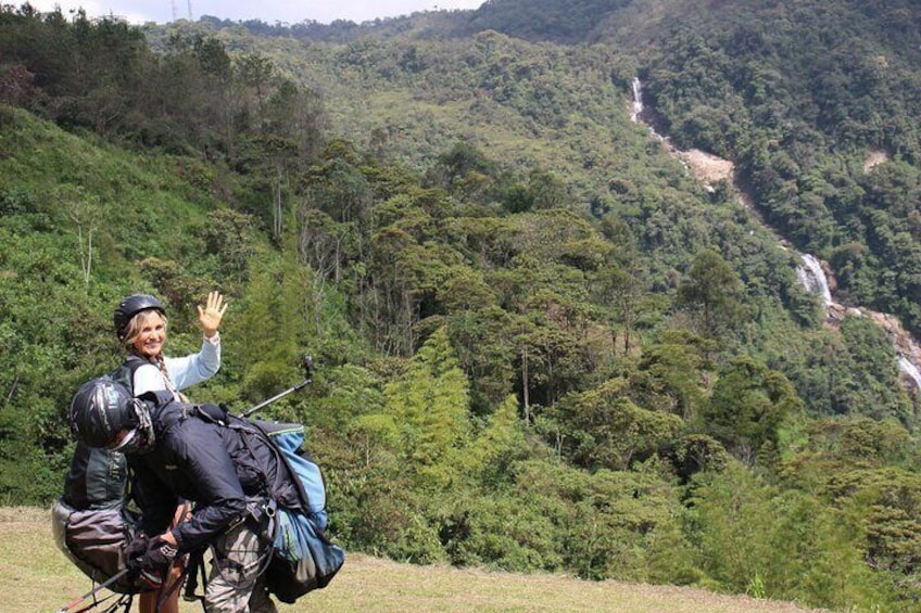 Paragliding flight over a valley of mountains and waterfalls + video