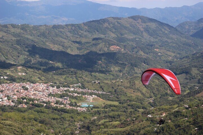 Paragliding flight over a valley of mountains and waterfalls + video