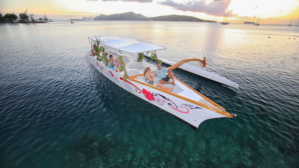 Show item 3 of 7. Sunset cruise in bay and sun dips below clouds in Bora Bora