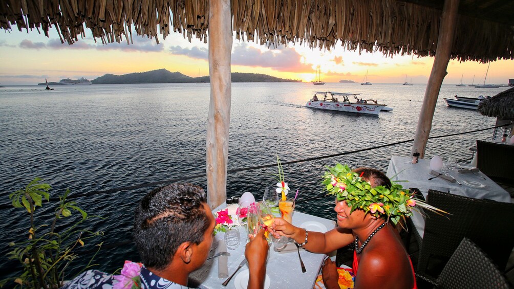 Show item 5 of 7. Couple from sunset cruise enjoying dinner at St James restaurant in Bora Bora
