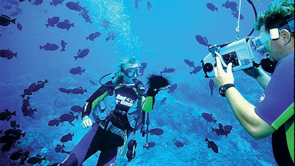 People filming under water while scuba diving in Maui