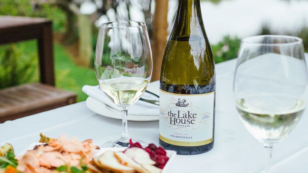 Bottle of wine with glasses and cuisine at The Lake House restaurant in Denmark, Australia