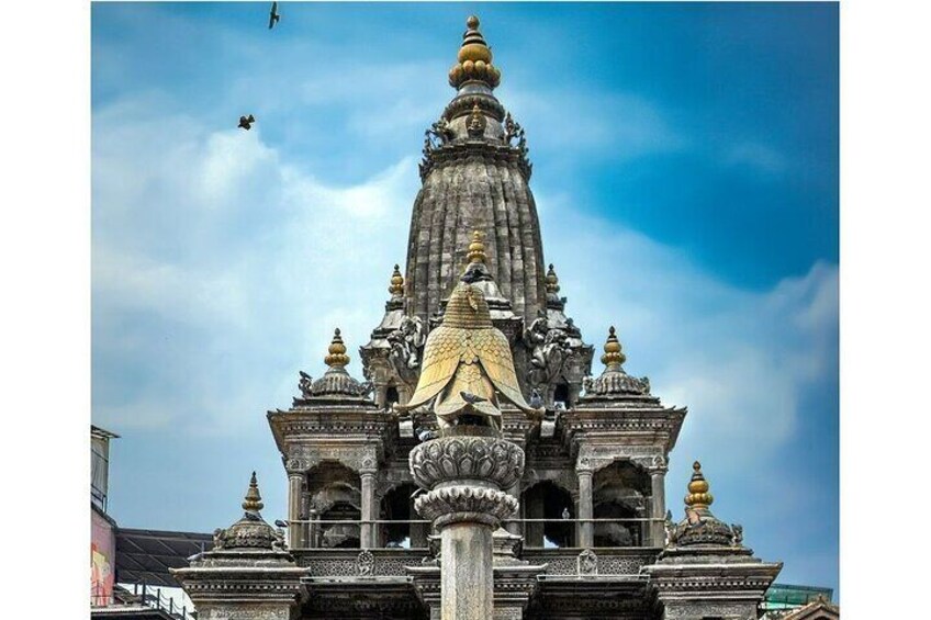 Krishna Mandir with garuda above the stone pillar saluting the god.