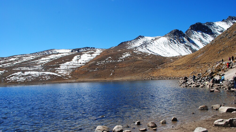 Tourists on the shore of a mountain lake in Mexico