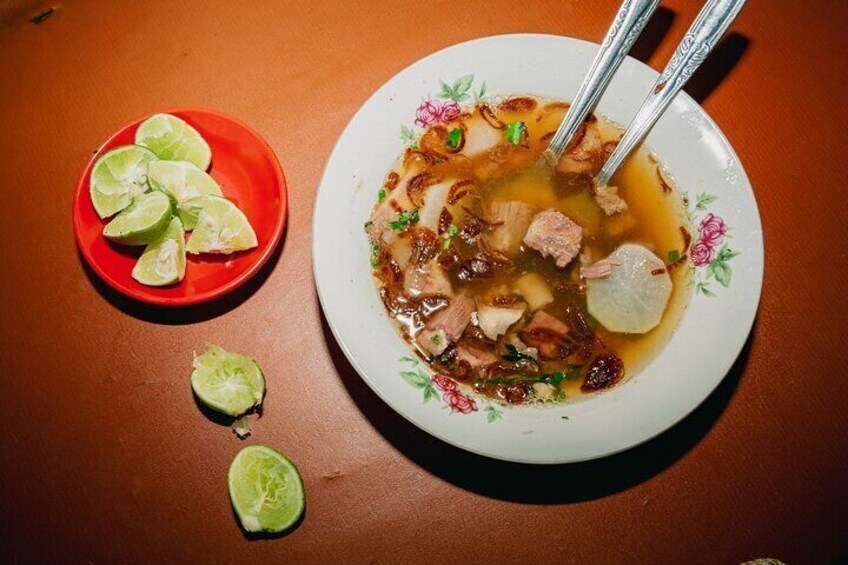 Soto babat beef soup with fried garlic and a squeeze of lime