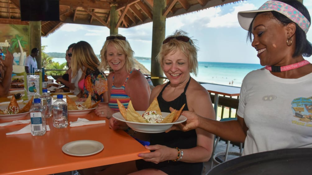 Women eat appetizers at an open air bar in Jamaica