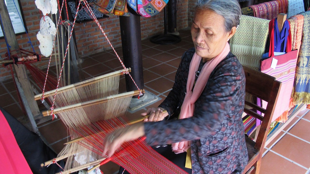 Woman works at silk loom in Hoi An