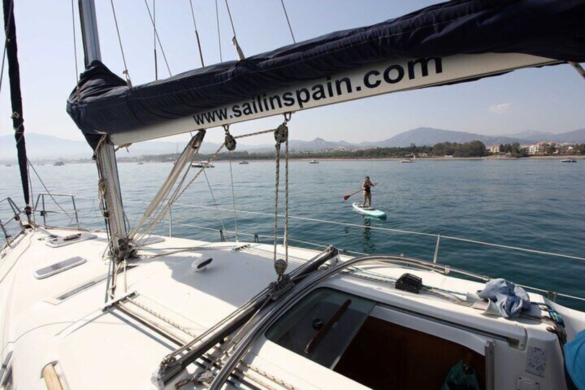 Anchored sailboat and paddle surf ride