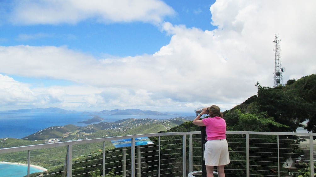Woman looking through binocular of surrounding island in St. Thomas & St. John