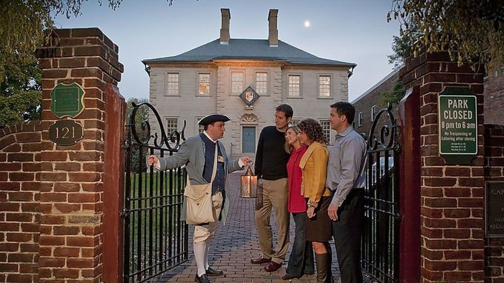 Tour guide dress in historical clothing talks to group on ghost and graveyard tour in Alexandria