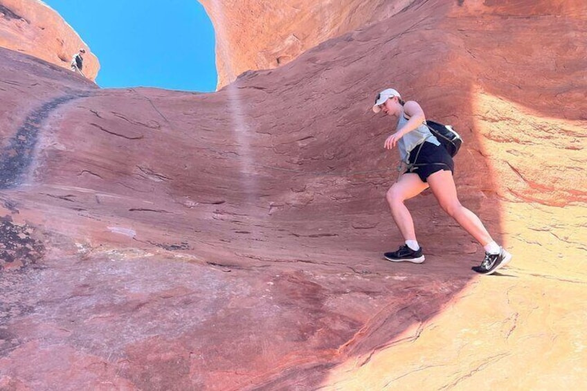 Climbing up through Cedar Arch with rope support,