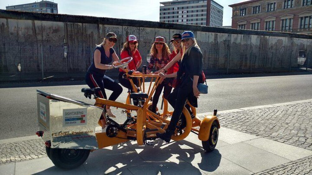 Happy and beautiful customers from UK on one of our Funbikes / ConferenceBikes / Teambikes in front of the Berlin Wall.