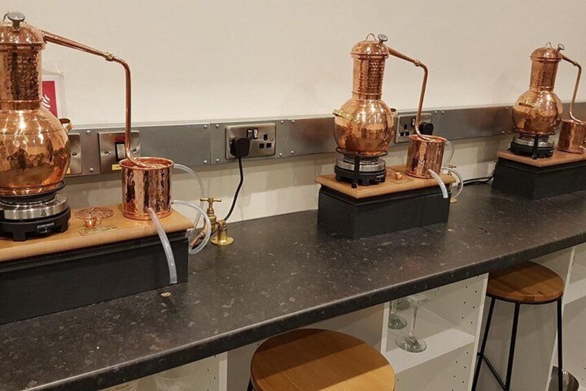 Distill a bottle of gin on mini copper stills