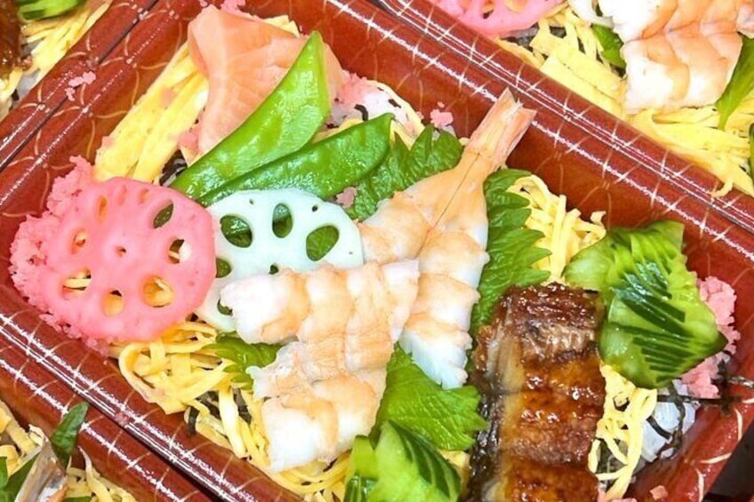sushi rice in a box or Bowl with a variety of ingredients sprinkled on top