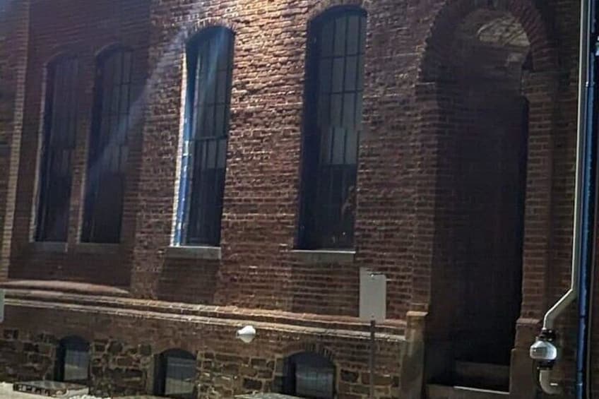 There's something peeking out of the window closest to the archway!