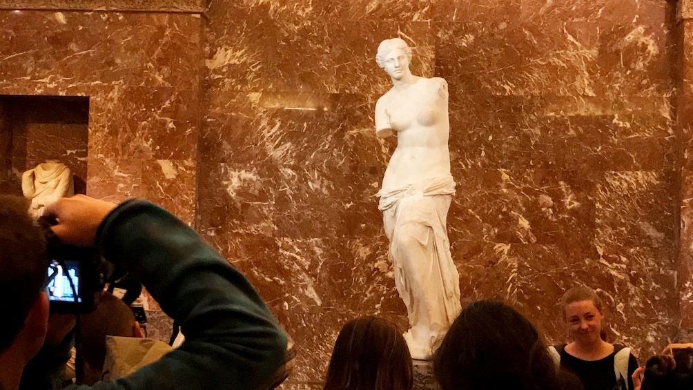 Group photograph sculpture on guided tour of the Louvre Museum in Paris