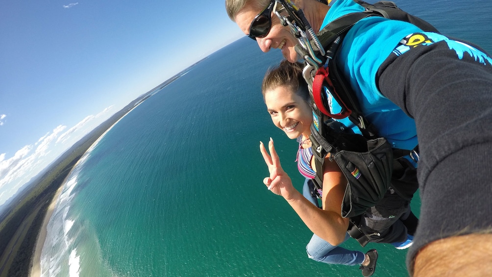 Skydivers with parachute deployed over Batemans Bay