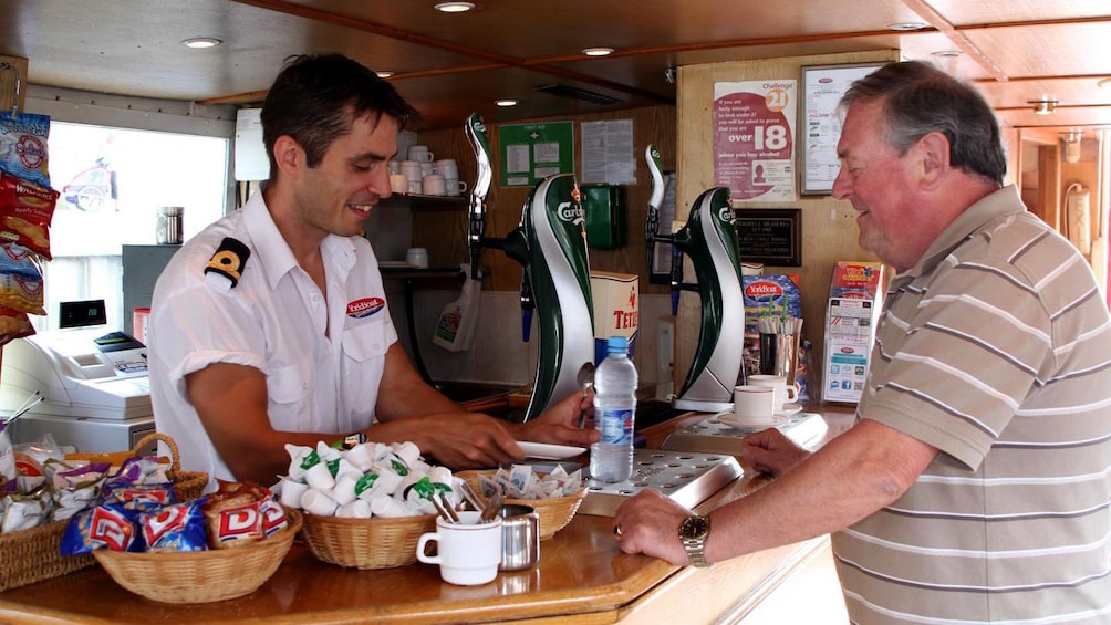 Man at food counter on small cruise boat in York