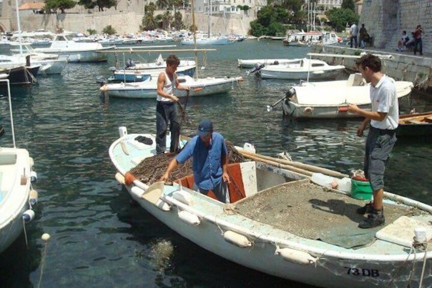 Fishing on Traditional Dubrovnik Fishing Boat in Front of Old City Walls