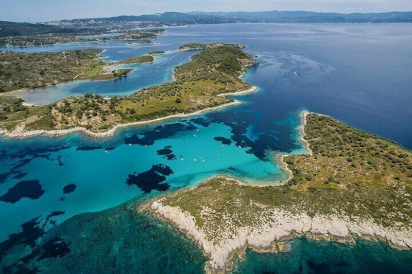 A small strait between Diaporos Island and Agios Isidoros island, the Blue Lagoon is a shallow bay with a white sandy sea bottom. This combination of white sand and the shallow depth allows for a very