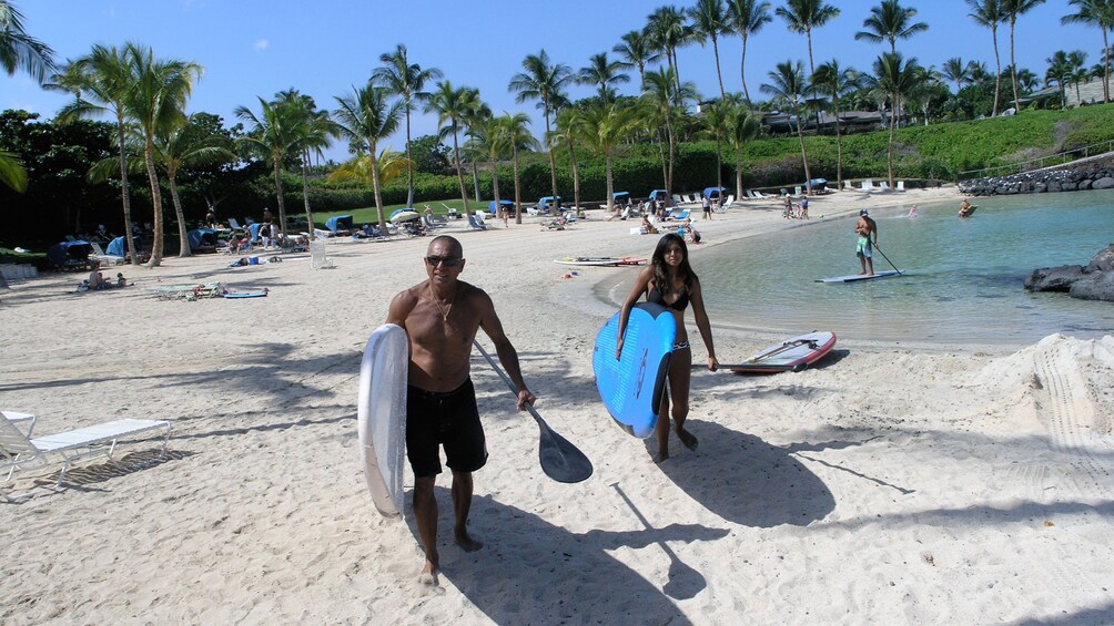 People with stand up paddles on the beach on Big Island