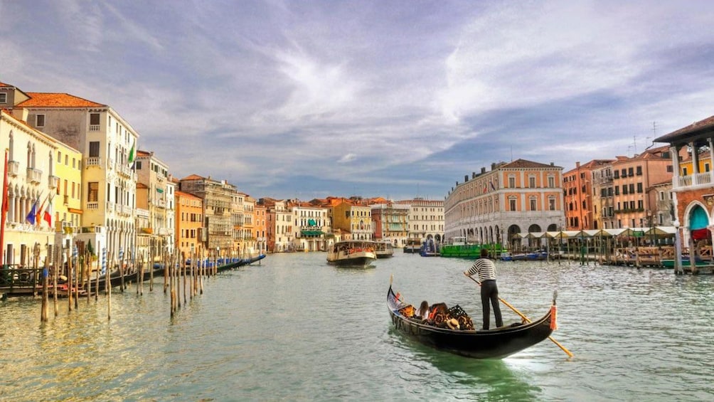 Single gondola paddles down waterway in Venice