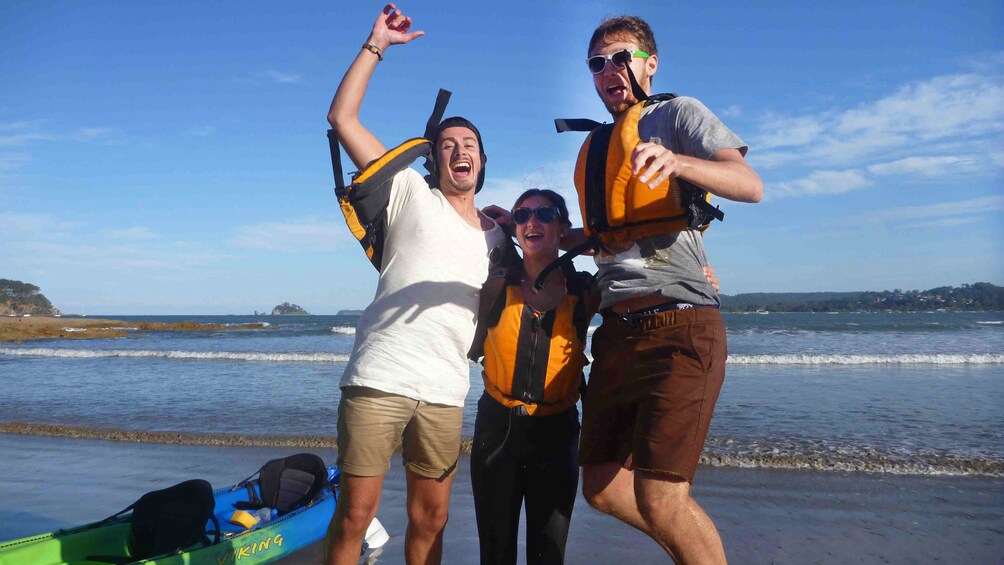 Three friends, having fun, jump for photo after kayaking in Batemans Bay