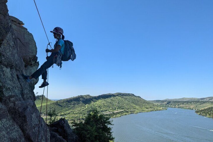Rappelling down with scenic views behind