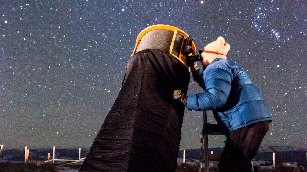 Man looking at the stars  through large telescope in Jackson Hole