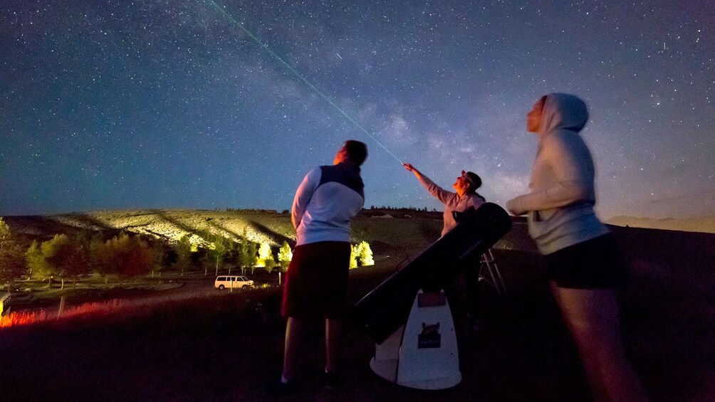 Group pointing a laser into the night sky in Jackson Hole