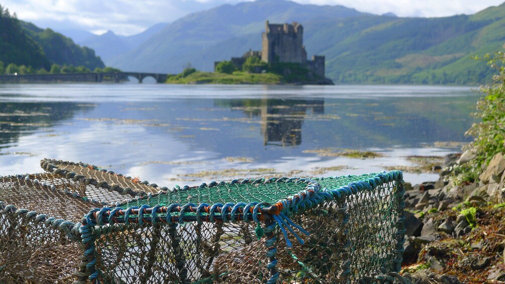 Crab pots on shore with Scottish castle in background