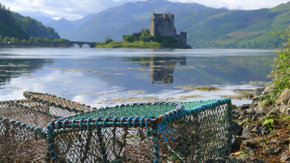 Crab pots on shore with Scottish castle in background