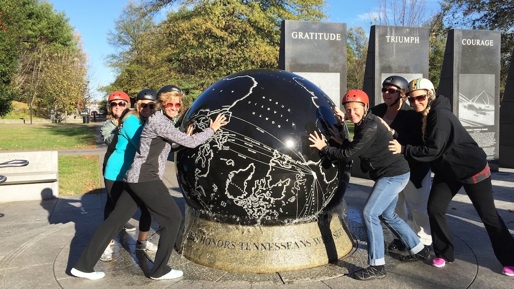 Segway group touch large globe in park in Nashville