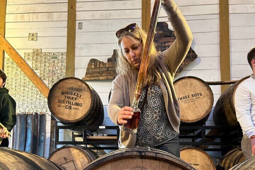 Hand filling a bottle at Whiskey Thief Distilling Company.