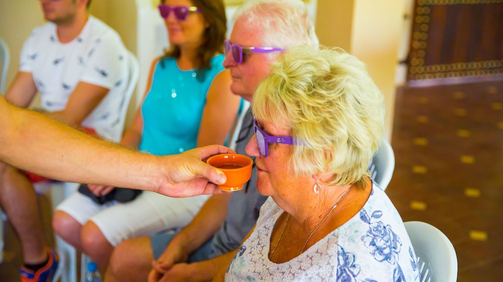 Woman with blacked out glasses smells ingredients during cooking class in Marrakech