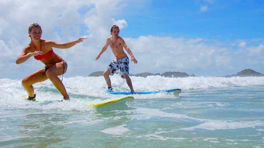 Show item 2 of 5. Man and woman surfing a wave in Australia