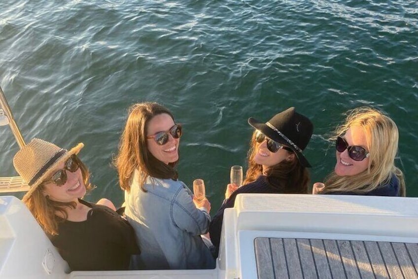 Girls sitting on back of yacht