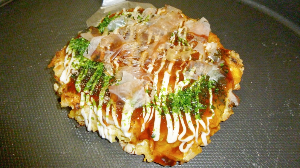 Freshly fried Okonomiyaki made at the Osaka Cooking Class in Osaka, Japan