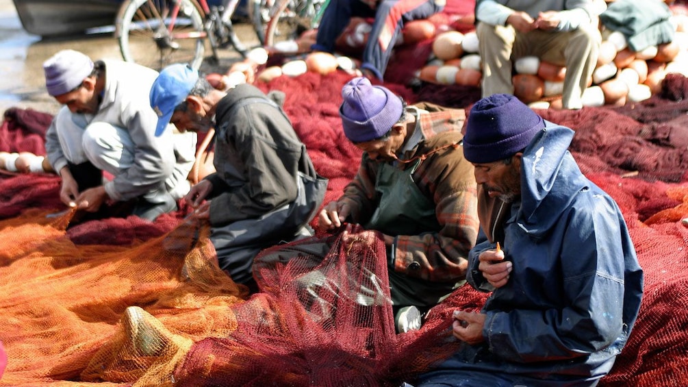 Fishermen repairing nets in Essaouira