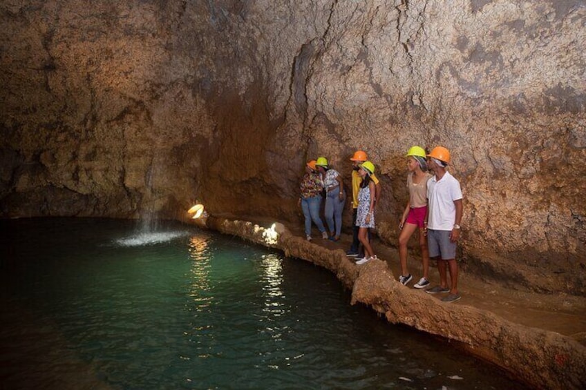 Guests at the natural waterfall inside of Harrison's Cave at the Harrison's Cave Eco-Adventure Park