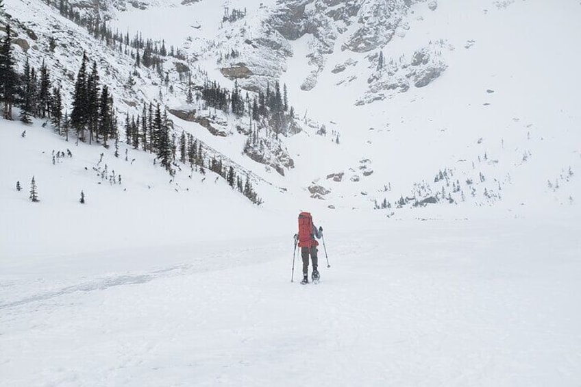 Client walks across the frozen Emerald Lake in Rocky Mountain National Park.