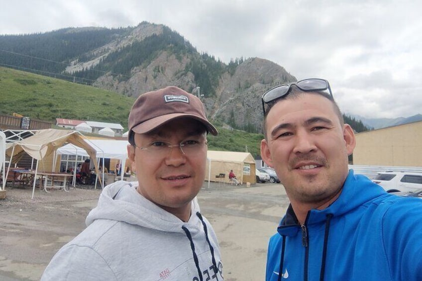 At the foothills of the lake, I am standing with my colleague, a notable car blogger from Kyrgyzstan.