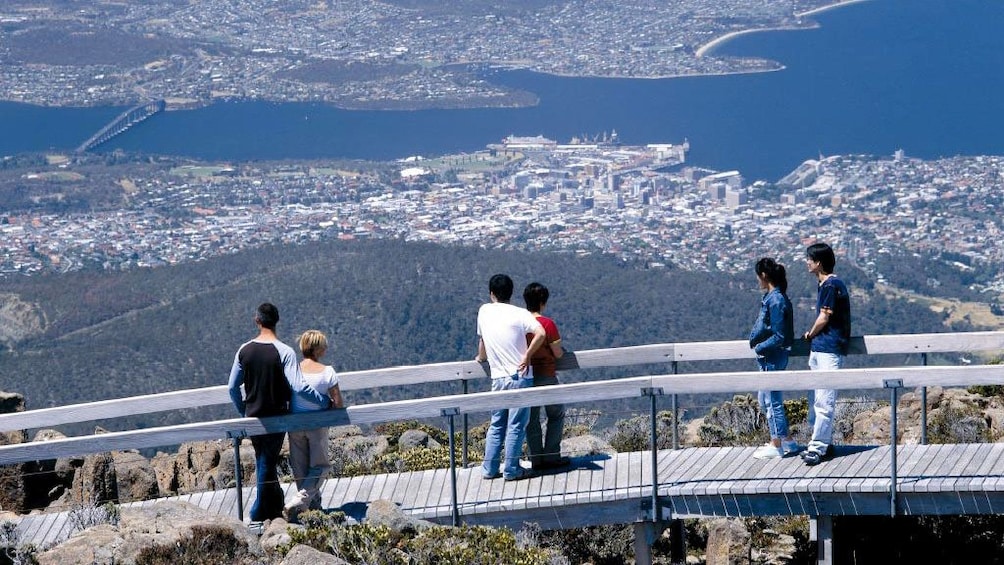 People on a boardwalk on Mount Wellington looking out at the view below in Australia