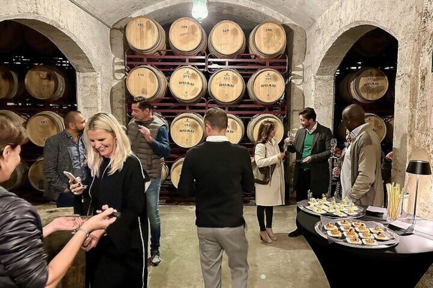 Bodega Mallorca premium spirit tasting. Aged brandy is extracted directly from the barrel and served into the glasses of the visitors of the winery and distillery tour. The century old cellar. 
