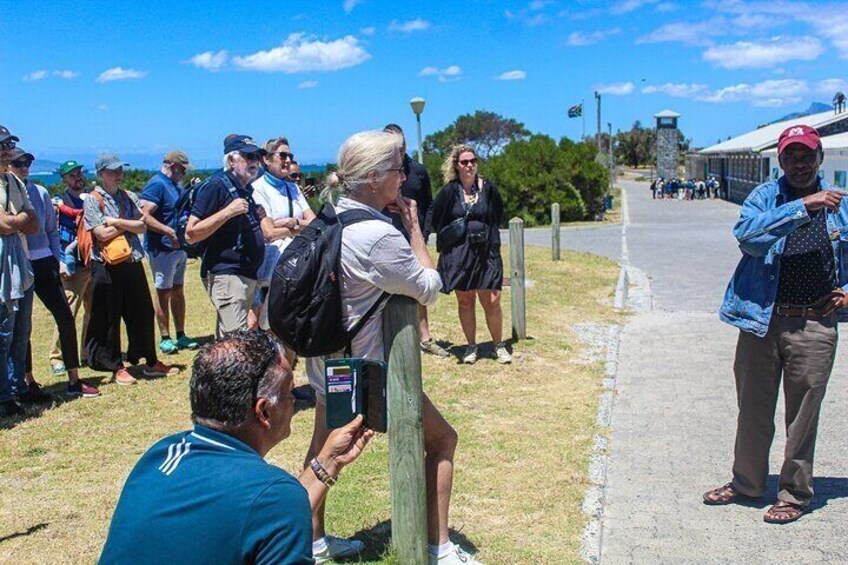 Travelers listen to an ex-inmate of Robben Island Maximum Security Prison.