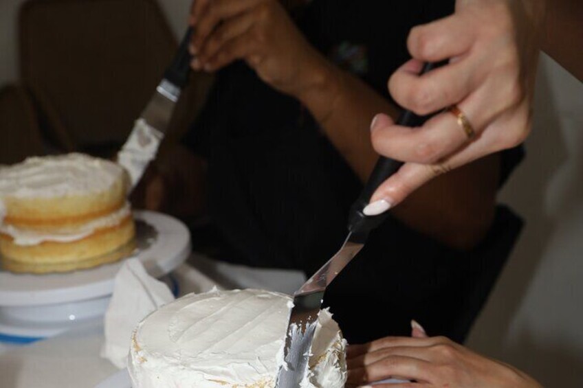 Learning how to apply a crumb coat to cake.