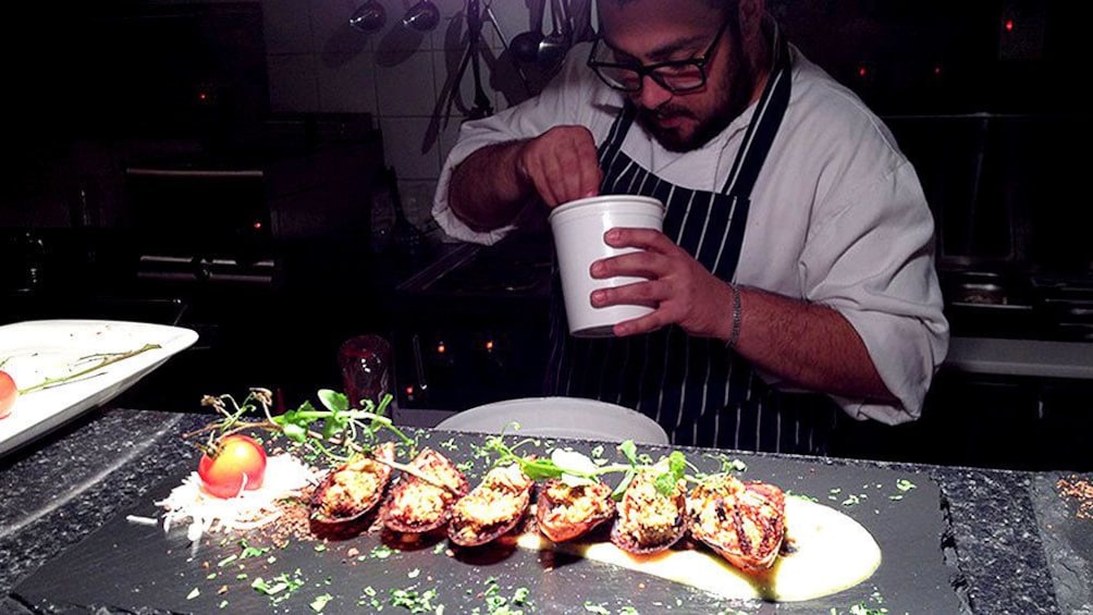 Show item 5 of 5. Chef putting finishing touches on cuisine during tapas tour in Galway