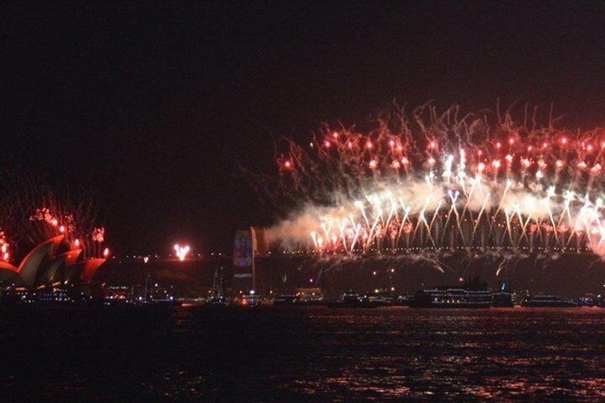 Opera House on left and Harbour Bridge on right exploding with fireworks TOGETHER
