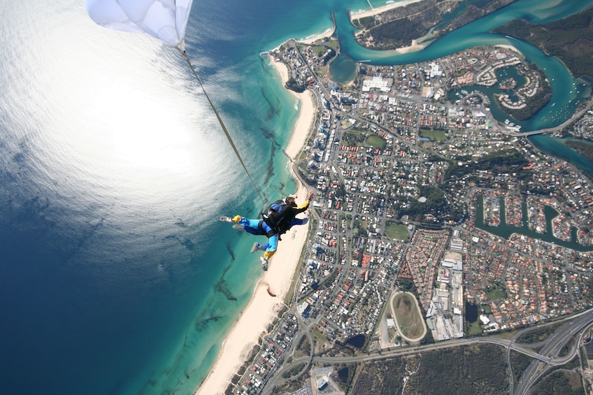 Show item 2 of 7. Skydivers deploying parachute over Gold Coast