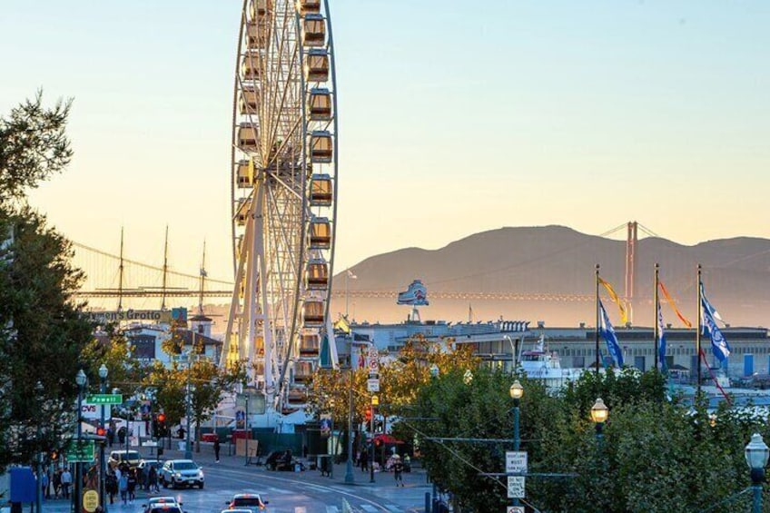 SkyStar Wheel Fisherman's Wharf at sunset with Golden Gate Bridge in the background